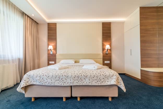 Double bed in Apartament Zdrojowy 323 with hotel linens and a pair of bedside lamps