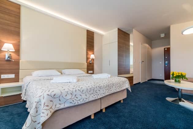View of the bed in Apartament Zdrojowy 323 from the side of the built-in wardrobe
