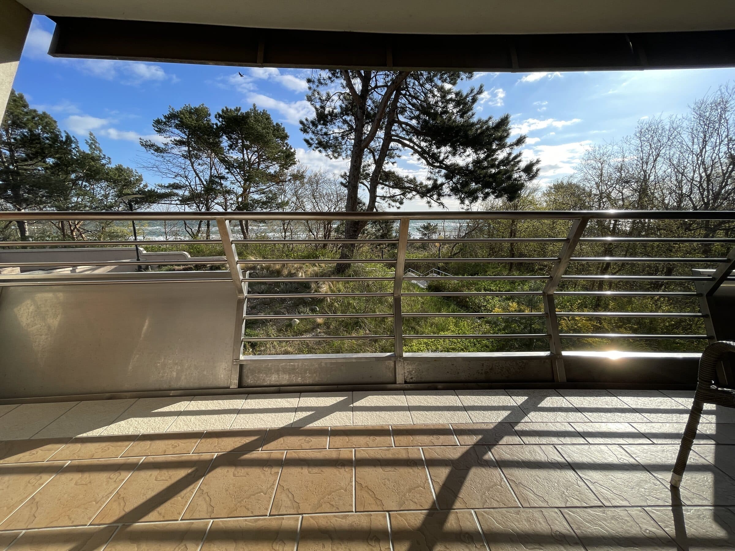 Balkon Apartamentu Zdrojowego 323 z widokiem na sosny i otwarty Bałtyk