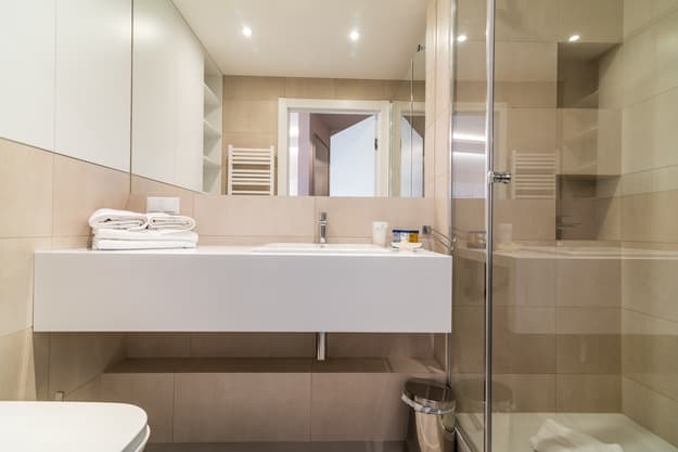 Łazienka w Apartamencie Zdrojowym 323 - umywalka z drewnianym blatem i przeszklony prysznic walk-in