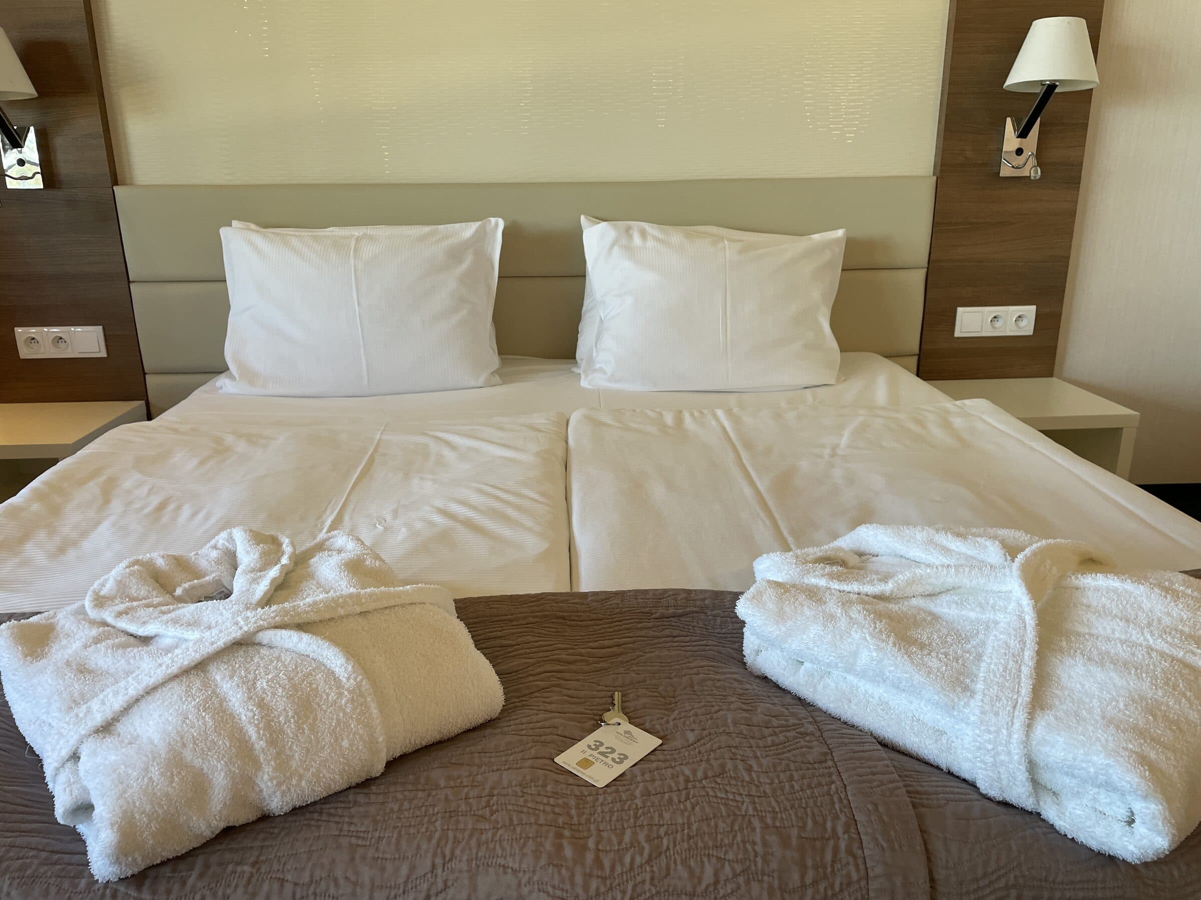 Apartament Zdrojowy 323 w Hotelu Dom Zdrojowy w Jastarni - łóżko z przygotowanymi szlafrokami i oświetleniem wieczornym