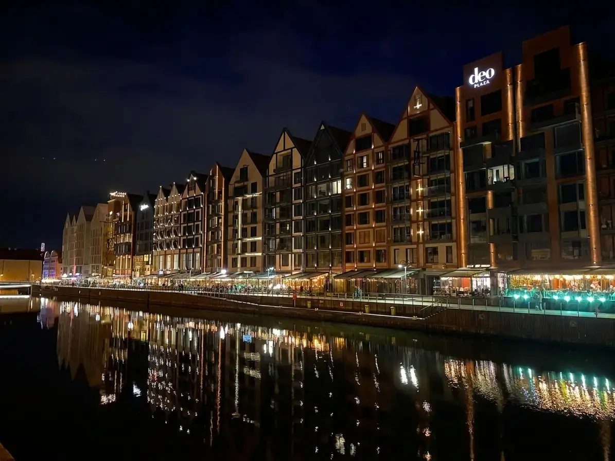 Wyspa Spichrzów in Gdańsk gespiegelt in der Motława bei Nacht - Startpunkt der Schiff-plus-Zug-Schleife nach Hel und Jastarnia, einer der kinoreifsten eintägigen Touren auf der Halbinsel.