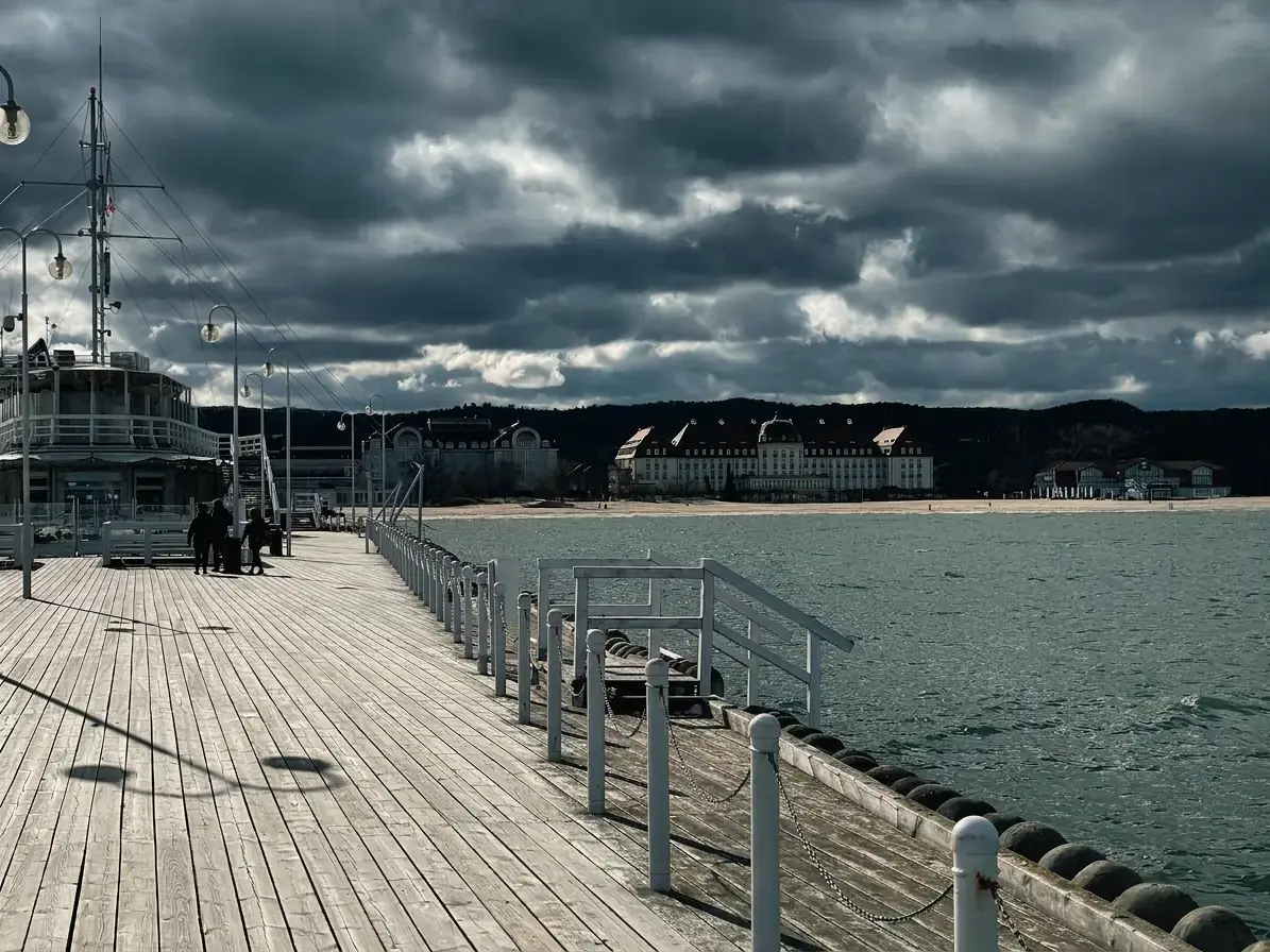 Blick von Europas längstem Holzpier in Sopot auf die Ostsee, den Sandstrand und die historische Architektur des Grand Hotel an der Küste.